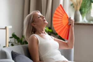 A woman with a hormone imbalance fanning herself
