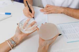 A woman comparing saline vs. silicone breast implants in the Hamptons